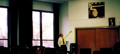  Dr. Moss revisists the York HS band room prior to demolition. Pointing to a signed photo of Georg Solti from Moss's time at York. 